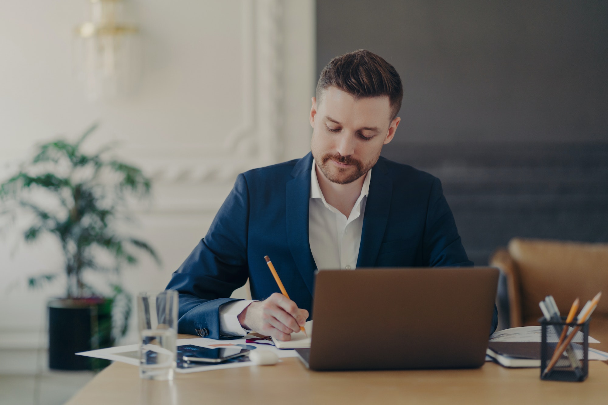 Serious concentrated skilled male entrepreneur checks financial accounting report